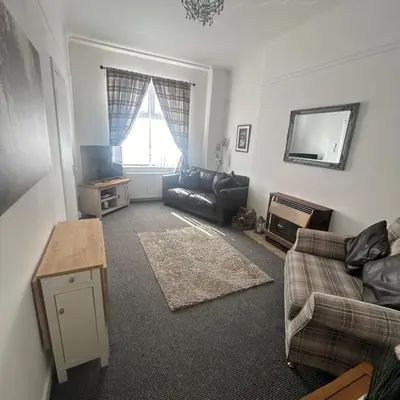 a living room with a couch and a tv at Hillhead Apartment in Coylton