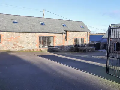 a brick building with a gate in front of it at The Steading in Dumfries
