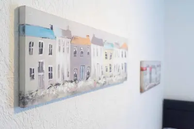 a painting of white buildings on a wall at Carlisle Comfort Terrace in Carlisle