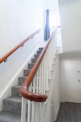 a staircase in a home with white walls and wooden railings at Carlisle Comfort Terrace in Carlisle