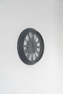 a black clock hanging on a white wall at Carlisle Comfort Terrace in Carlisle