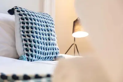 a pillow sitting on a couch next to a lamp at The Annick Suite No1 - Donnini Apartments in Irvine