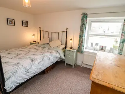a bedroom with a bed and a window and a table at Seahaven in Maryport