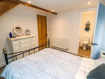 a bedroom with a bed and a bathroom with a toilet at Seahaven in Maryport