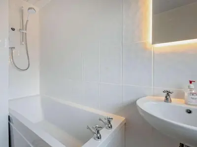 a white bathroom with a sink and a bath tub at 3 Bed in Keswick 95858 in Keswick