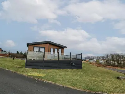 a small house on the side of the road at Debonair Lodge in Newton Stewart