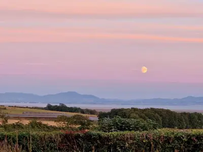 a full moon rising over the water at sunset at Beautiful Countryside Lodge with Outstanding Views - Pass the Keys in Dumfries