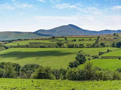 a green field with mountains in the background at 3 Bed in Wigton oc-95374 in Uldale