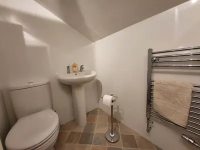 a white bathroom with a toilet and a sink at Holly Cottage Grasmere in Grasmere