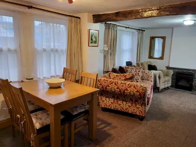 a living room with a table and a couch at Holly Cottage Grasmere in Grasmere