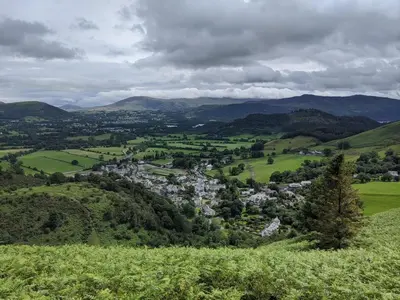 a small town in a green valley with mountains at Oakside Cottage Braithwaite in Braithwaite