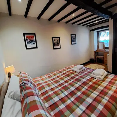 a bedroom with a bed with two towels on it at Oakside Cottage Braithwaite in Braithwaite