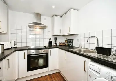 a kitchen with white cabinets and a sink at The Igloo Viewoint City Centre Stay & Free Parking in Moffat