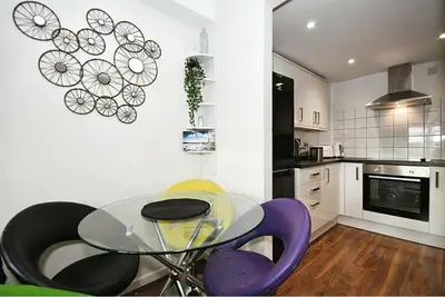 a kitchen with a glass table and purple chairs at The Igloo Viewoint City Centre Stay & Free Parking in Moffat