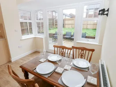 a dining room with a table with plates and wine glasses at Linga House - 3 Bedrooms - Sleeps 5 in Frizington