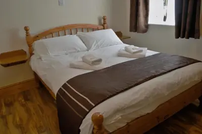 a bedroom with a bed with two towels on it at Sea Breeze Guest House in Douglas