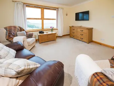 a living room with two couches and a television at Shellhill Cottage at Clauchan Holiday Cottages in Gatehouse of Fleet