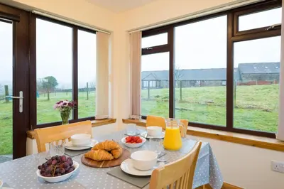a dining room with a table with food on it at Shellhill Cottage at Clauchan Holiday Cottages in Gatehouse of Fleet