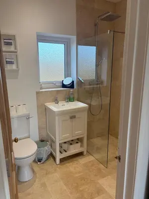 a bathroom with a toilet and a shower and a sink at Mains of Greenlaw Cottage in Castle Douglas
