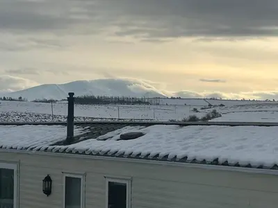 a snow covered roof of a house with a snow covered field at Skiddaw Lodges- The Lake District in Plumbland