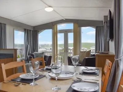 a dining room table with glasses and plates on it at Skiddaw Lodges- The Lake District in Plumbland