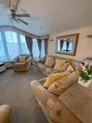 a living room with couches and a ceiling fan at Skiddaw Lodges- The Lake District in Plumbland
