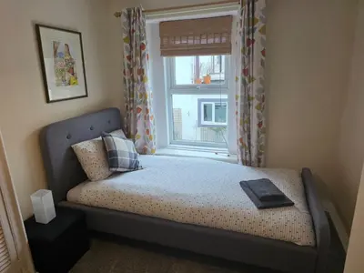 a small bedroom with a bed with a window at Cute Cottage in Historic Port Carlisle 12miles from M6 in Port Carlisle