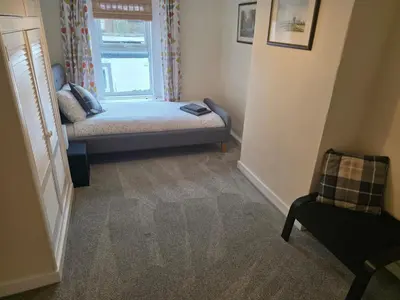 a small bedroom with a bed and a window at Cute Cottage in Historic Port Carlisle 12miles from M6 in Port Carlisle