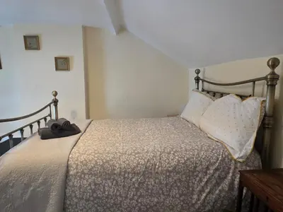 a bedroom with a bed with a wooden frame and pillows at Cute Cottage in Historic Port Carlisle 12miles from M6 in Port Carlisle