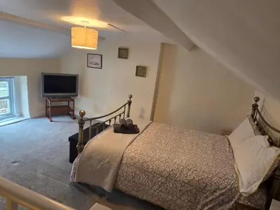a bedroom with a bed and a flat screen tv at Cute Cottage in Historic Port Carlisle 12miles from M6 in Port Carlisle