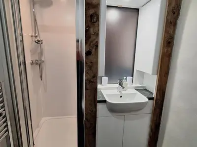 a white bathroom with a sink and a shower at Field House in Keswick