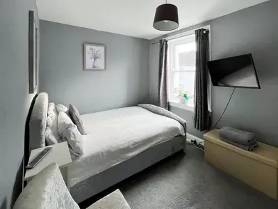 a small bedroom with a bed and a window at Fleet Townhouse in Gatehouse of Fleet