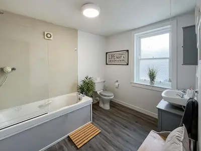 a bathroom with a tub and a toilet and a sink at Fleet Townhouse in Gatehouse of Fleet