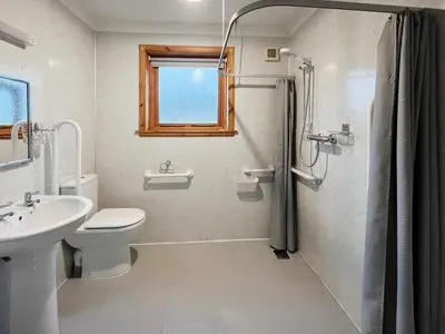 a bathroom with a shower and a toilet and a sink at Shellhill Cottage in Kirkcudbright