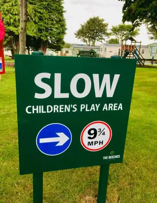 a sign for a slow childrens play area at 28 The Beeches in Wigton