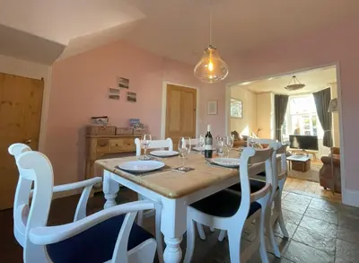 a dining room with a table and white chairs at 45 Eskin Street in Keswick