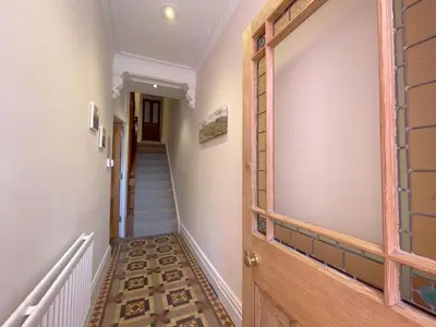 a hallway with a wooden door and stairs at 45 Eskin Street in Keswick