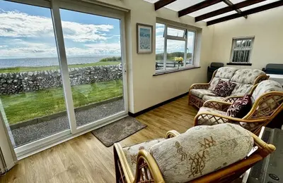 a living room with a view of the ocean at Airyolland in Newton Stewart