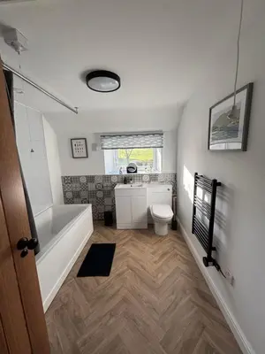 a bathroom with a tub and a toilet and a sink at The Barn in Ellonby