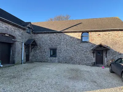 a brick house with a car parked in front of it at The Barn in Ellonby