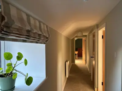 a hallway with a window and a plant on a window sill at The Barn in Ellonby