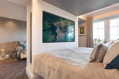 a bedroom with a large painting on the wall at The Retreat - Ridgestone in Penruddock