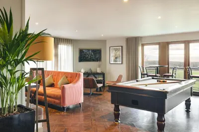 a living room with a pool table and a couch at The Retreat - Ridgestone in Penruddock