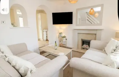 a living room with two white couches and a fireplace at Ploughmans Cottage in Brampton