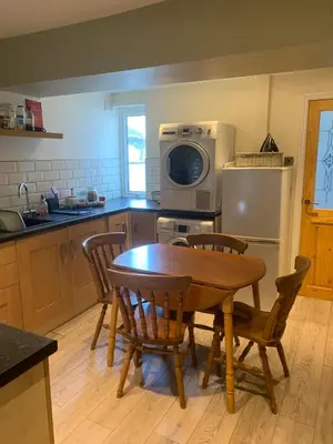 a kitchen with a table and chairs and a microwave at Lilac Cottage - Fell views & walks from the door in Cleator Moor