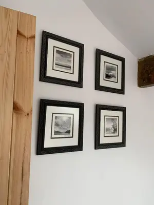 four framed pictures on a white wall at Lilac Cottage - Fell views & walks from the door in Cleator Moor