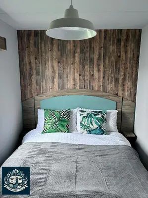 a bedroom with a large bed with a wooden headboard at Jazmine's Place in Ayr