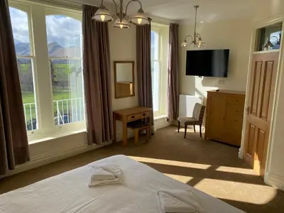 a hotel room with a bed and a television at Berkeley House in Keswick