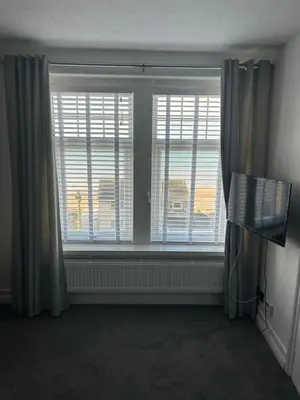 a room with two large windows with blinds at Lakenhow in Seascale