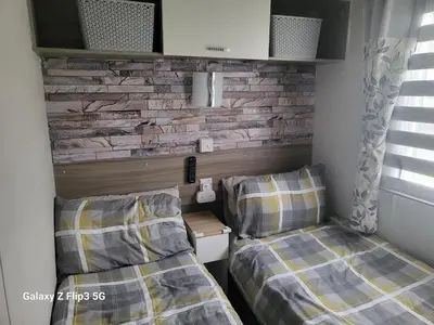 two beds in a room with a brick wall at MLR at Craig Tara Bay View in Ayr